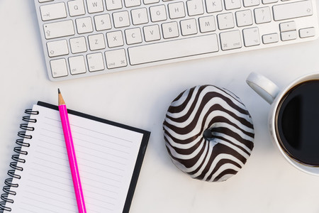 Computer keyboard notebook coffee donut white background